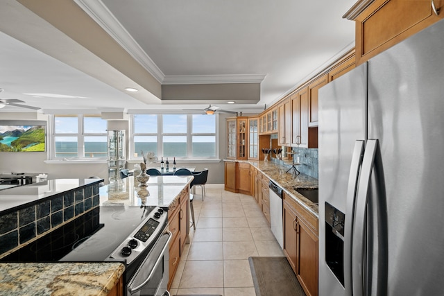 kitchen featuring appliances with stainless steel finishes, light stone counters, and ceiling fan