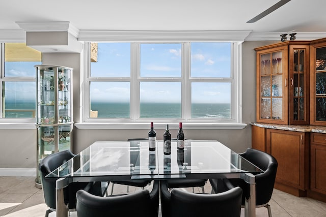 dining room with light tile flooring, plenty of natural light, and a water view