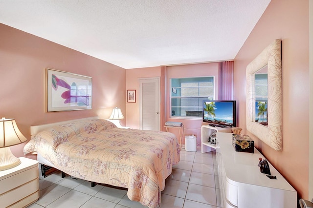 bedroom featuring light tile floors and a textured ceiling