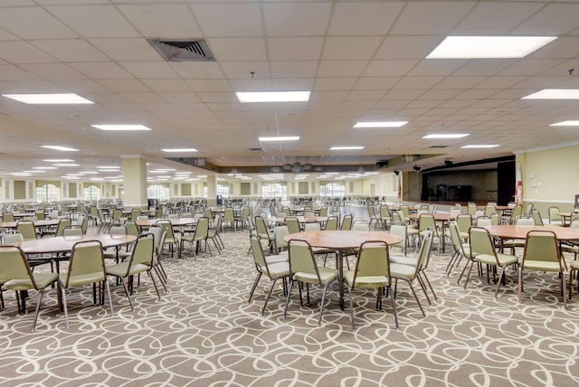 dining space featuring light carpet and a drop ceiling