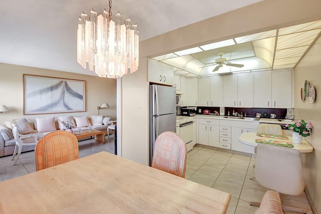 kitchen featuring white cabinets, light tile floors, sink, and ceiling fan with notable chandelier