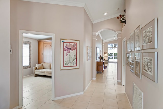 hall featuring plenty of natural light, light tile patterned floors, high vaulted ceiling, and decorative columns