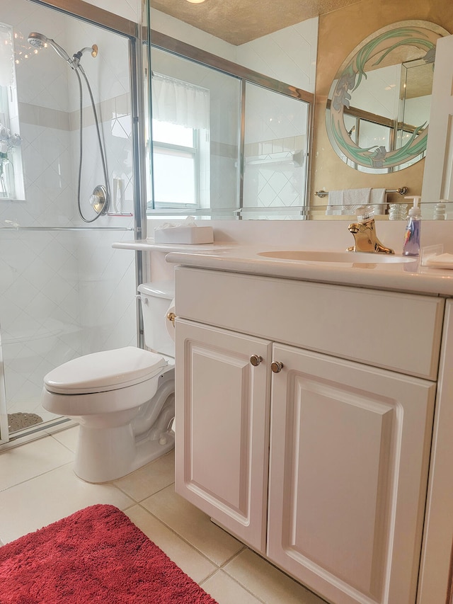 bathroom with tile patterned flooring, a textured ceiling, toilet, vanity, and a shower with shower door