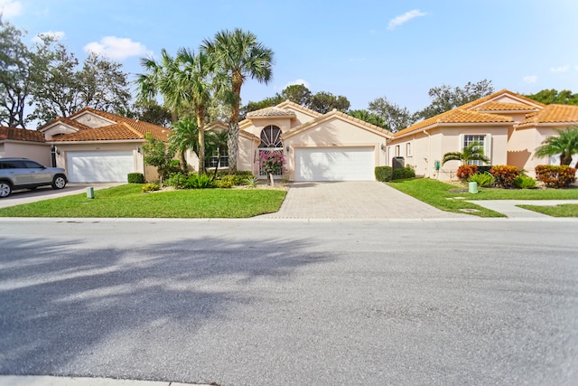 mediterranean / spanish home with a front yard and a garage