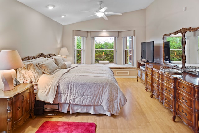 bedroom with ceiling fan, light hardwood / wood-style floors, and vaulted ceiling