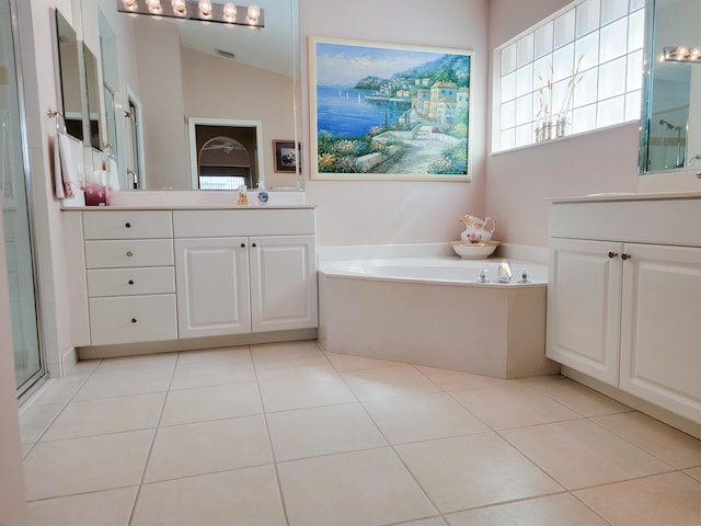 bathroom with tile patterned flooring, vanity, independent shower and bath, and vaulted ceiling