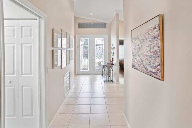 tiled foyer entrance with vaulted ceiling, crown molding, and french doors