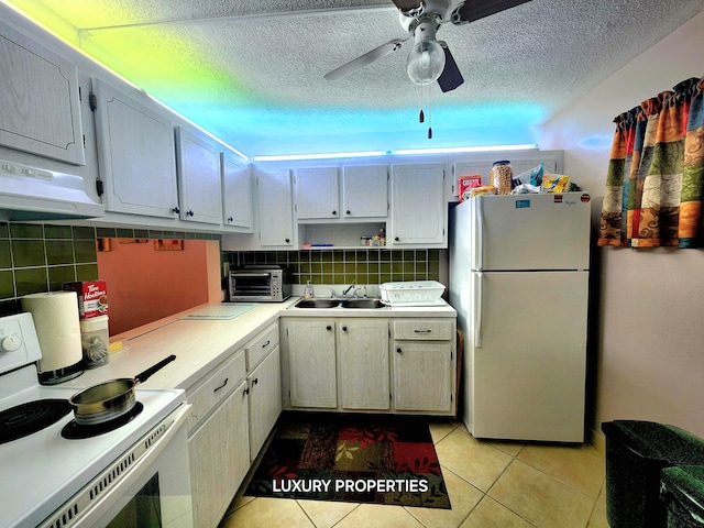 kitchen featuring ceiling fan, white appliances, sink, light tile floors, and a textured ceiling