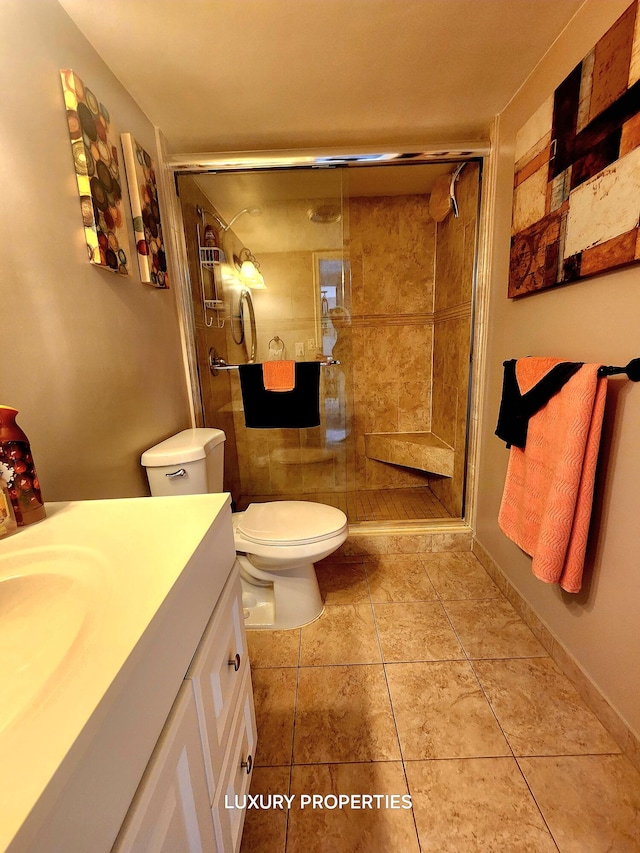 bathroom featuring oversized vanity, toilet, walk in shower, and tile flooring