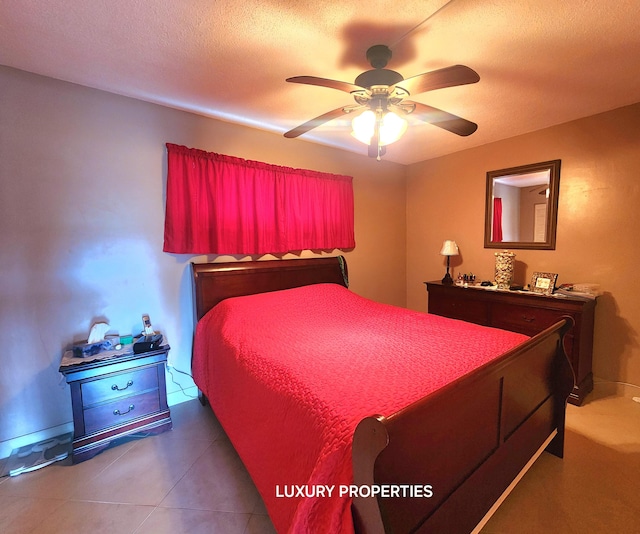 bedroom featuring a textured ceiling, dark tile flooring, and ceiling fan