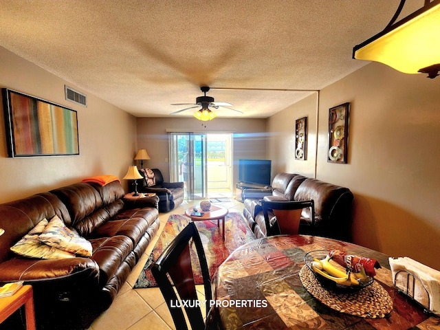 tiled living room featuring a textured ceiling and ceiling fan