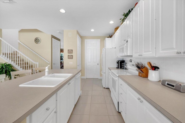 kitchen with light tile floors, tasteful backsplash, white appliances, white cabinetry, and sink