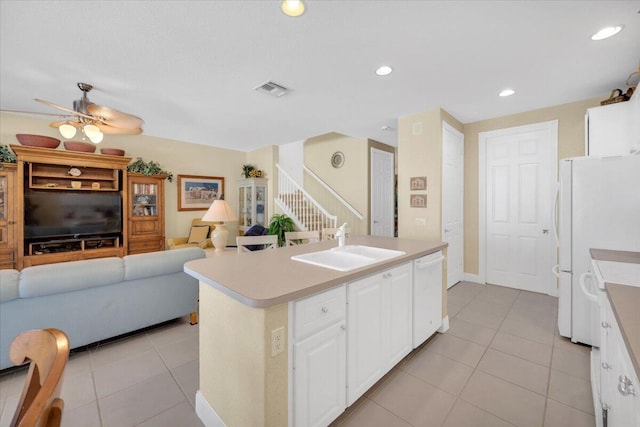 kitchen with an island with sink, white appliances, ceiling fan, sink, and white cabinets