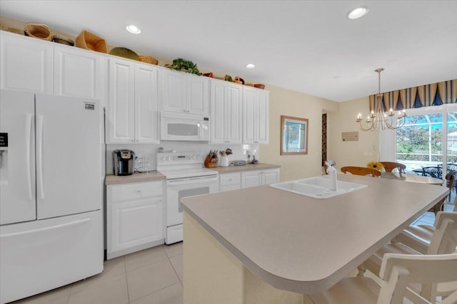 kitchen with white appliances, a notable chandelier, white cabinetry, and sink