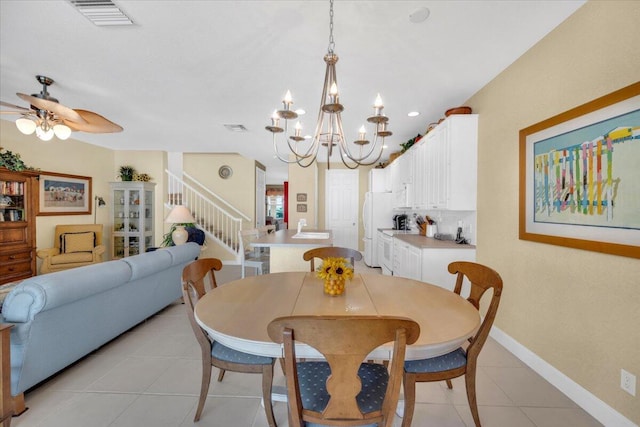 dining room with light tile flooring and ceiling fan with notable chandelier