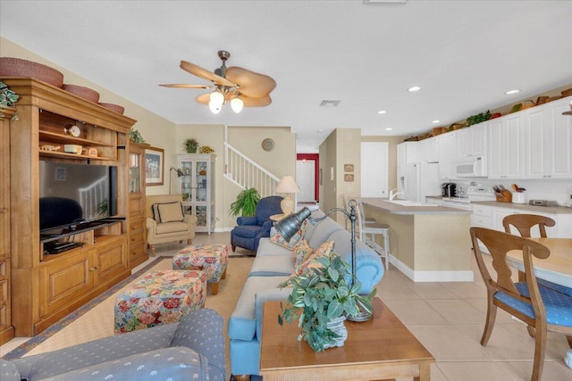 tiled living room with ceiling fan and sink