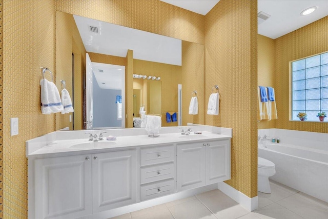 bathroom featuring toilet, dual sinks, tile flooring, oversized vanity, and a bath