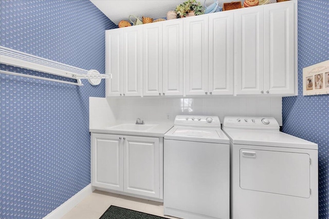 laundry room with cabinets, independent washer and dryer, sink, and light tile floors