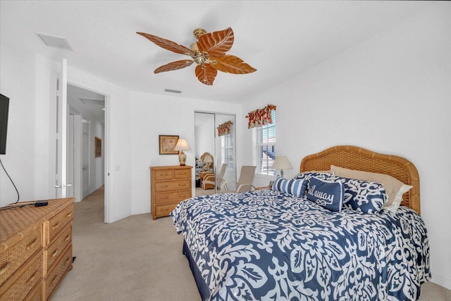 bedroom featuring light carpet, a closet, and ceiling fan