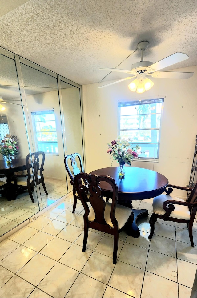 tiled dining area featuring a textured ceiling, ceiling fan, and a wealth of natural light