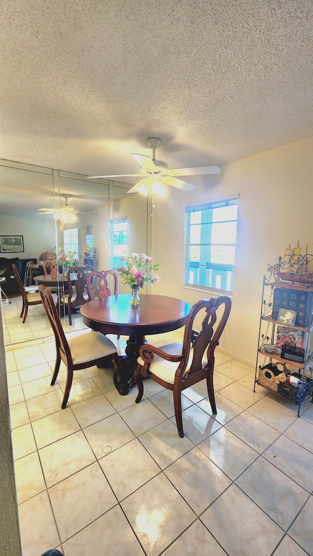 dining room with ceiling fan, a textured ceiling, and light tile patterned floors