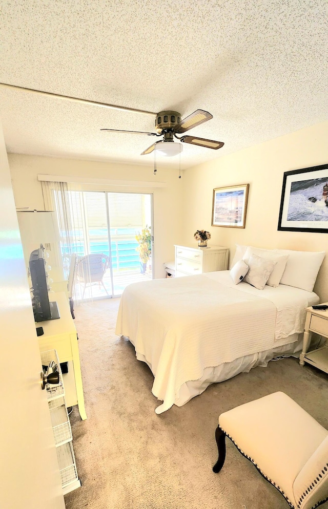 bedroom featuring access to outside, a textured ceiling, light colored carpet, and ceiling fan