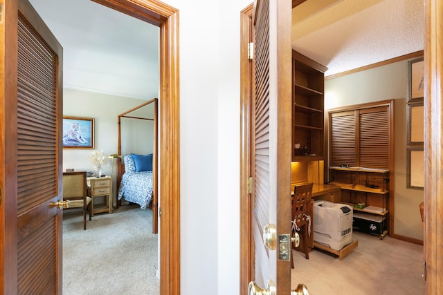 corridor featuring light carpet, a textured ceiling, and crown molding