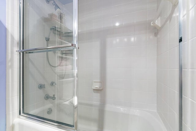 bathroom with shower / bath combination with glass door