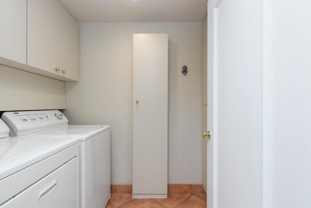 laundry room with light tile flooring, independent washer and dryer, and cabinets