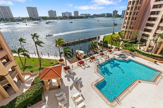 view of swimming pool featuring a water view and a patio area