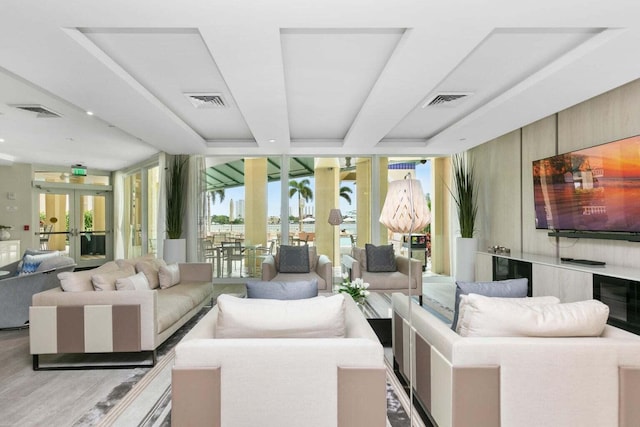 living room featuring french doors, light hardwood / wood-style floors, and expansive windows