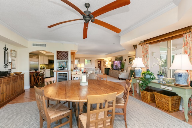 tiled dining area featuring ornamental molding, ceiling fan, and a textured ceiling