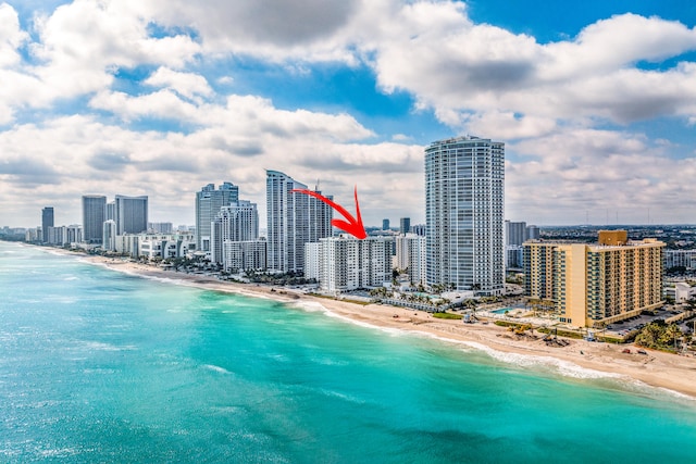 drone / aerial view featuring a beach view and a water view