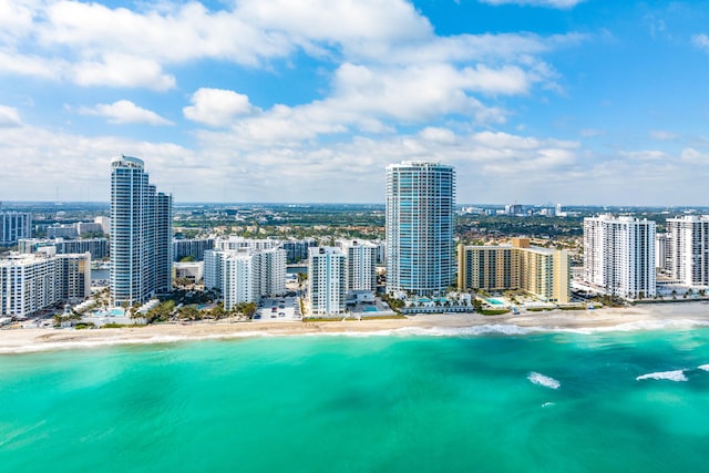 birds eye view of property featuring a beach view and a water view