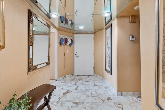 corridor with a drop ceiling and light tile floors