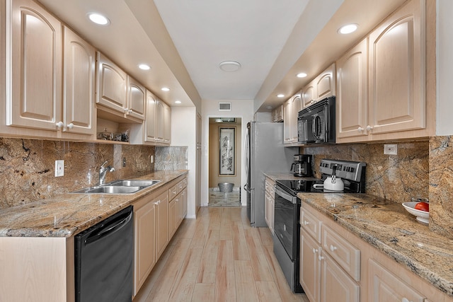 kitchen featuring backsplash, light hardwood / wood-style flooring, sink, and black appliances