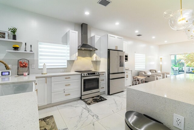 kitchen with stainless steel range with electric stovetop, decorative light fixtures, white refrigerator, and wall chimney range hood