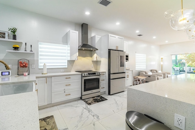 kitchen with marble finish floor, stainless steel appliances, visible vents, a sink, and wall chimney exhaust hood