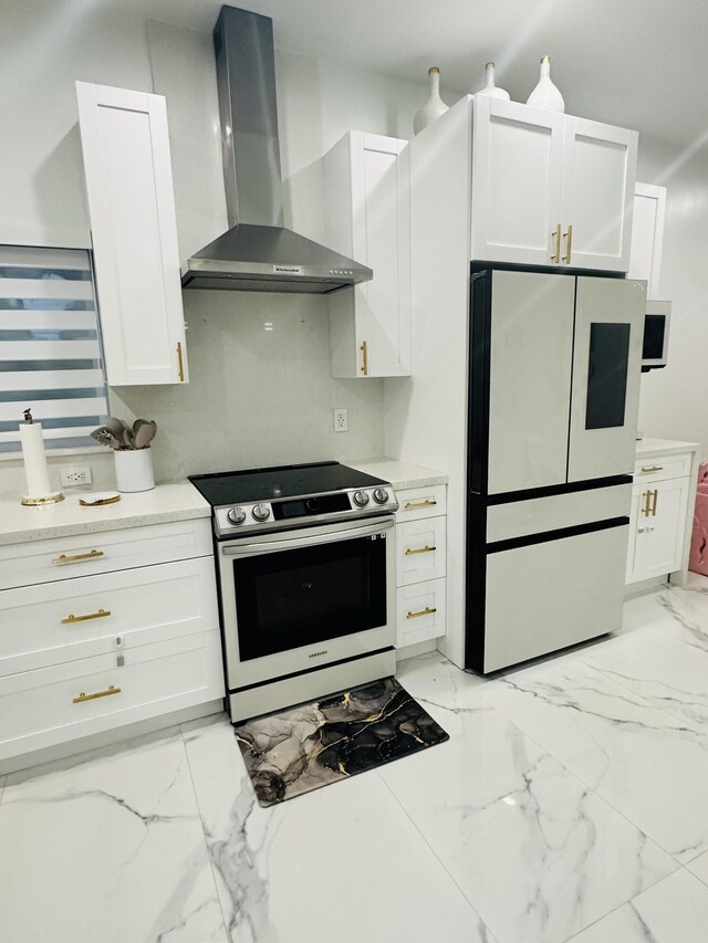 kitchen featuring wall chimney exhaust hood, refrigerator, electric stove, and white cabinetry