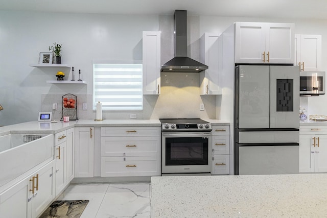 kitchen with white cabinetry, marble finish floor, wall chimney range hood, appliances with stainless steel finishes, and backsplash