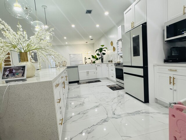 kitchen with white cabinetry, light stone counters, kitchen peninsula, pendant lighting, and appliances with stainless steel finishes