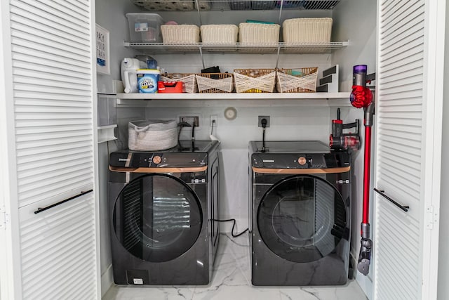 laundry area with marble finish floor, laundry area, and washing machine and clothes dryer