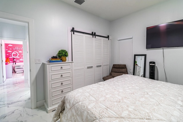 bedroom featuring marble finish floor, a barn door, and visible vents