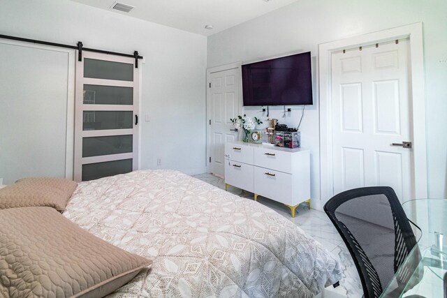 bedroom featuring marble finish floor, a barn door, and visible vents