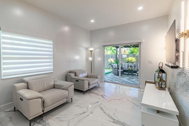 living room featuring recessed lighting, marble finish floor, and baseboards