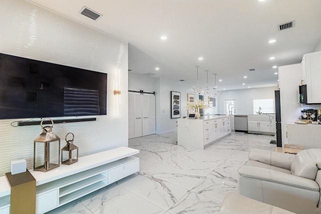 living area featuring recessed lighting, marble finish floor, visible vents, and a barn door