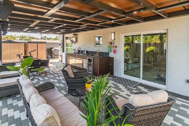 view of patio with wine cooler, outdoor lounge area, fence, and a sink