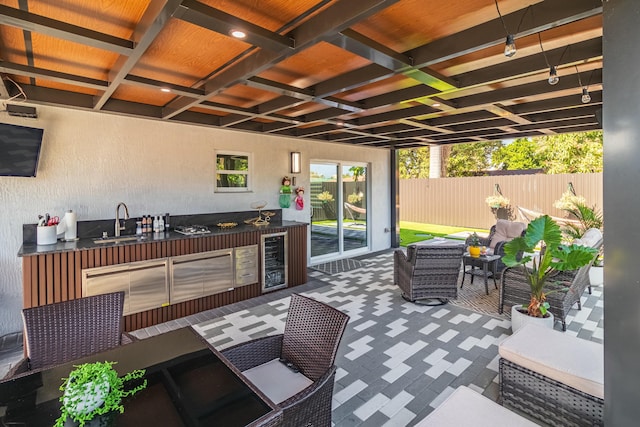 view of patio with beverage cooler, an outdoor hangout area, area for grilling, a sink, and fence