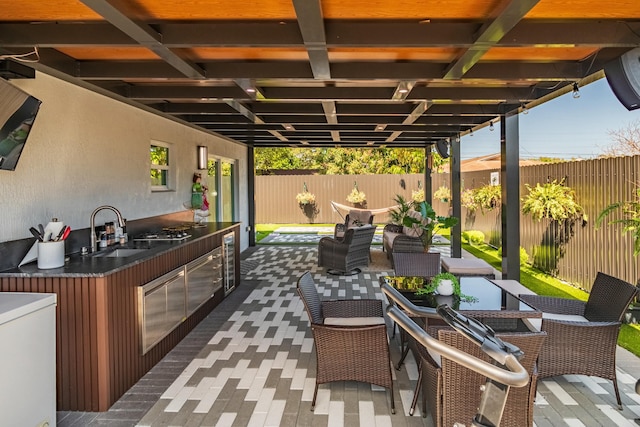 view of patio with a fenced backyard, outdoor dining area, a sink, and area for grilling