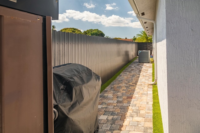 view of patio featuring a fenced backyard, central AC, and grilling area